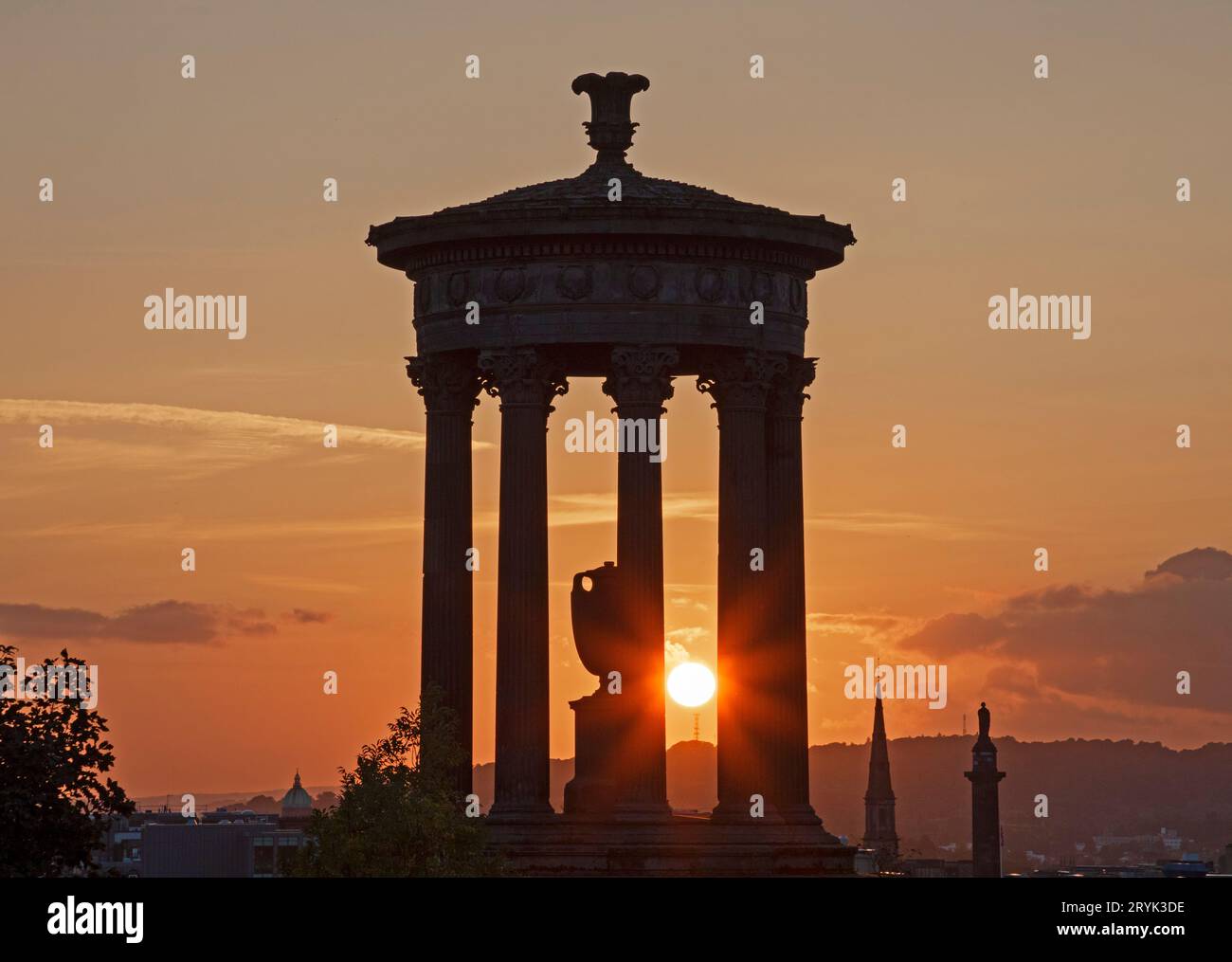 Calton Hill, Édimbourg, Écosse, Royaume-Uni. 1 octobre 2023. Un crépuscule doux à 17 degrés centigrades et un coucher de soleil animé au célèbre monument où des hunderds de touristes se rassemblaient pour voir le soleil plonger sous l'horizon. Photo : une silhouette du monument Dugald Stewart avec le soleil couchant jetant un regard à travers les piliers Banque D'Images