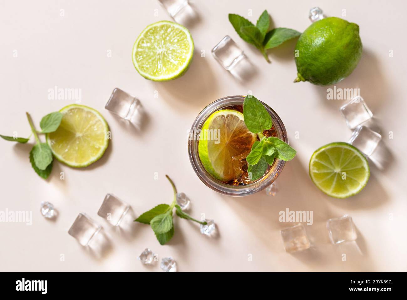 Boisson alcoolisée Cuba libre, Coca-Cola avec glaçons ou limonade sur fond marron pastel. Vue de dessus de l'arrière-plan de la mise à plat Banque D'Images