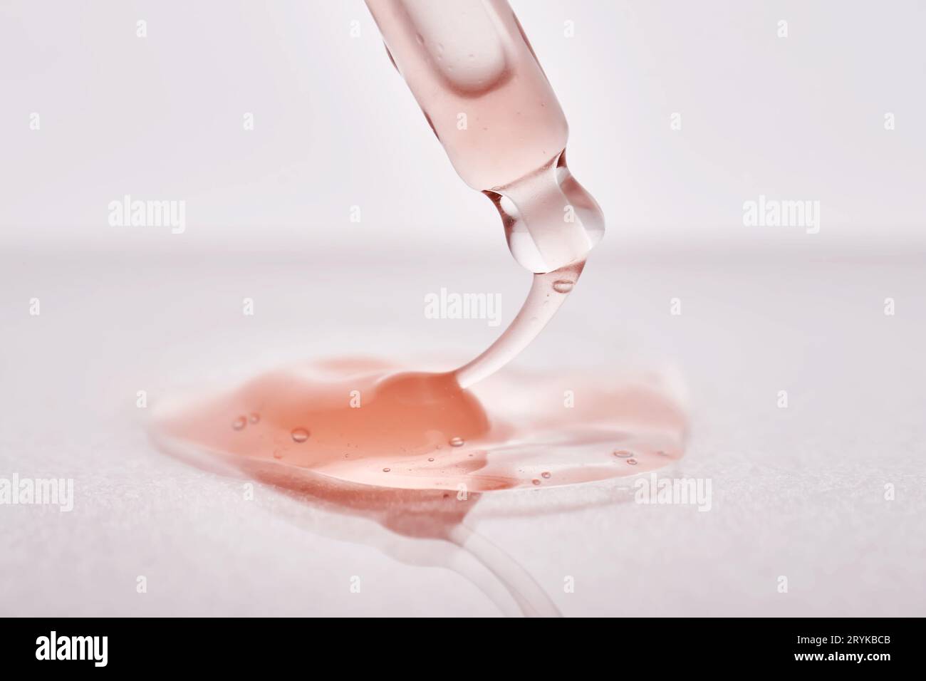 Pipette avec un gros plan cosmétique rose visqueux. Banque D'Images