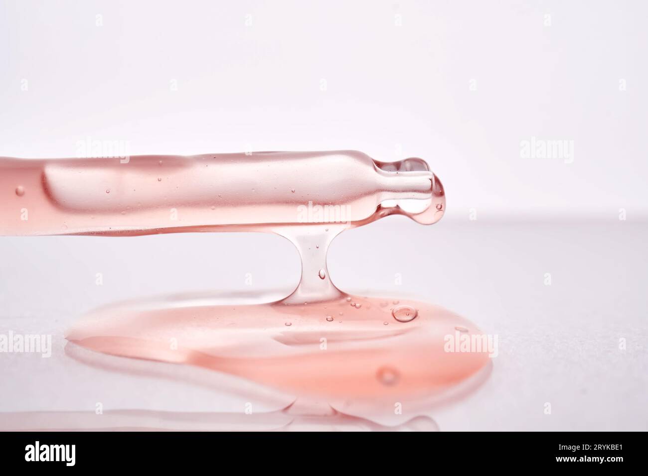 Pipette avec un gros plan cosmétique rose visqueux. Banque D'Images