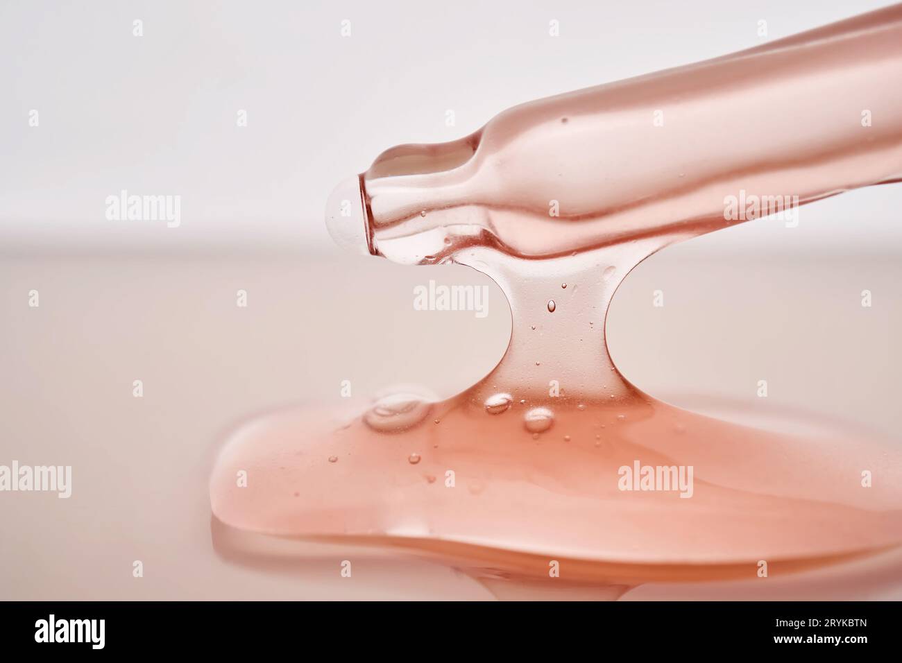 Pipette avec un gros plan cosmétique rose visqueux. Banque D'Images