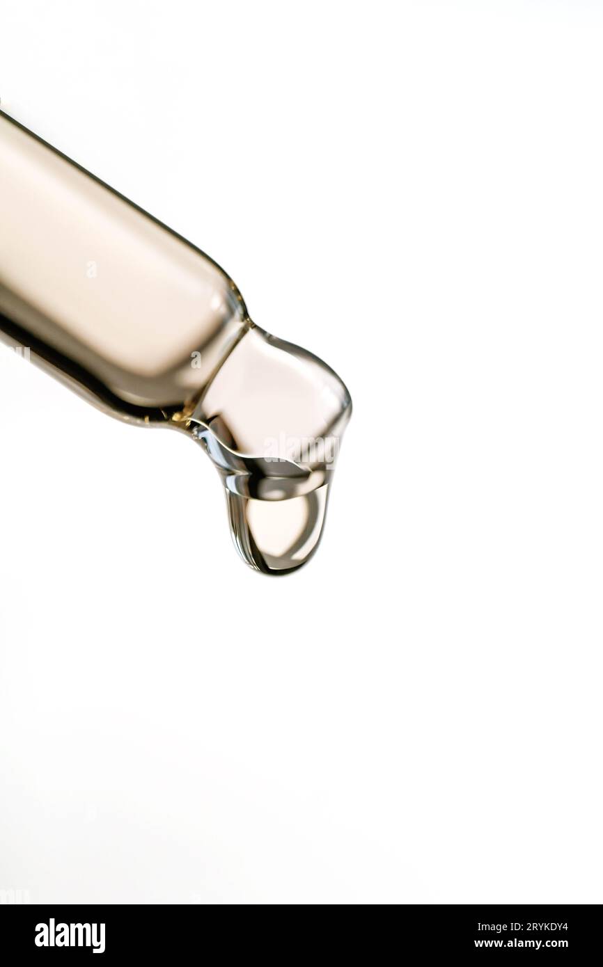 Une goutte d'huile cosmétique tombe de la pipette Banque D'Images