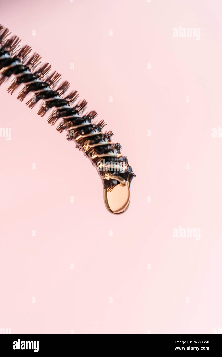 Une goutte d'huile pour les sourcils et les cils tombe de la brosse Banque D'Images