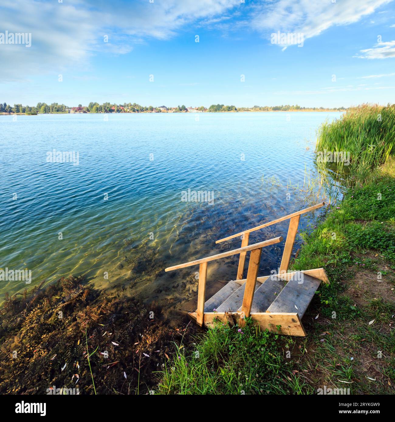 Été lac plage calme avec du bois des pentes à l'eau Banque D'Images