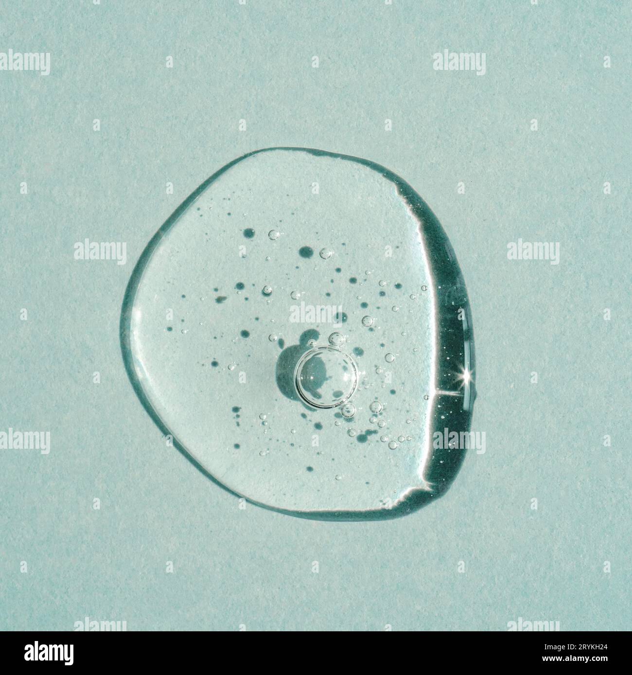 Une goutte de gel cosmétique transparent sur fond vert. Banque D'Images