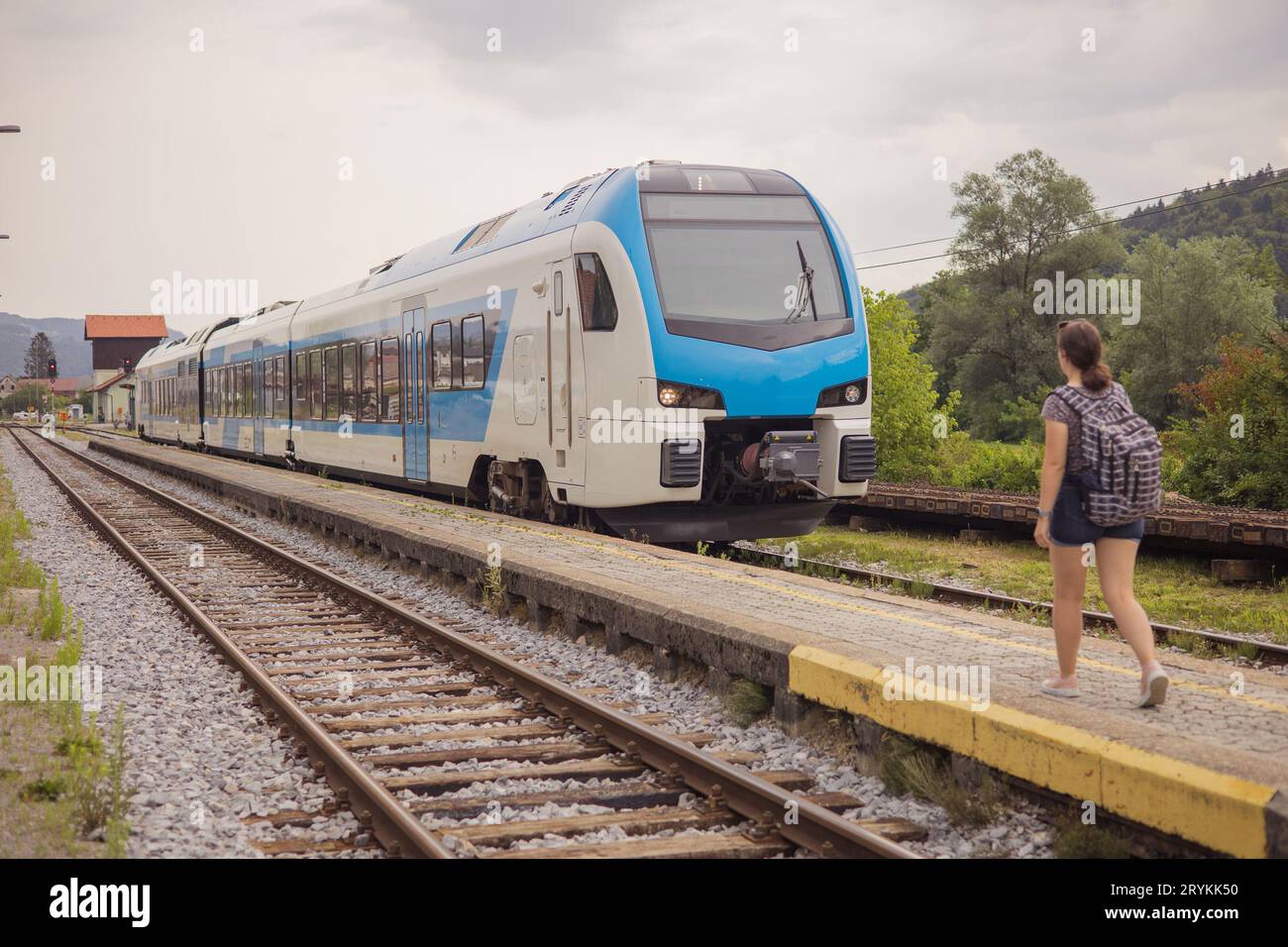 Nouveau type de train dans la gare rurale de Trebnje, Slovénie venant à un arrêt sur une plate-forme étroite. Femme inconnue sur le point d'entrer. Banque D'Images