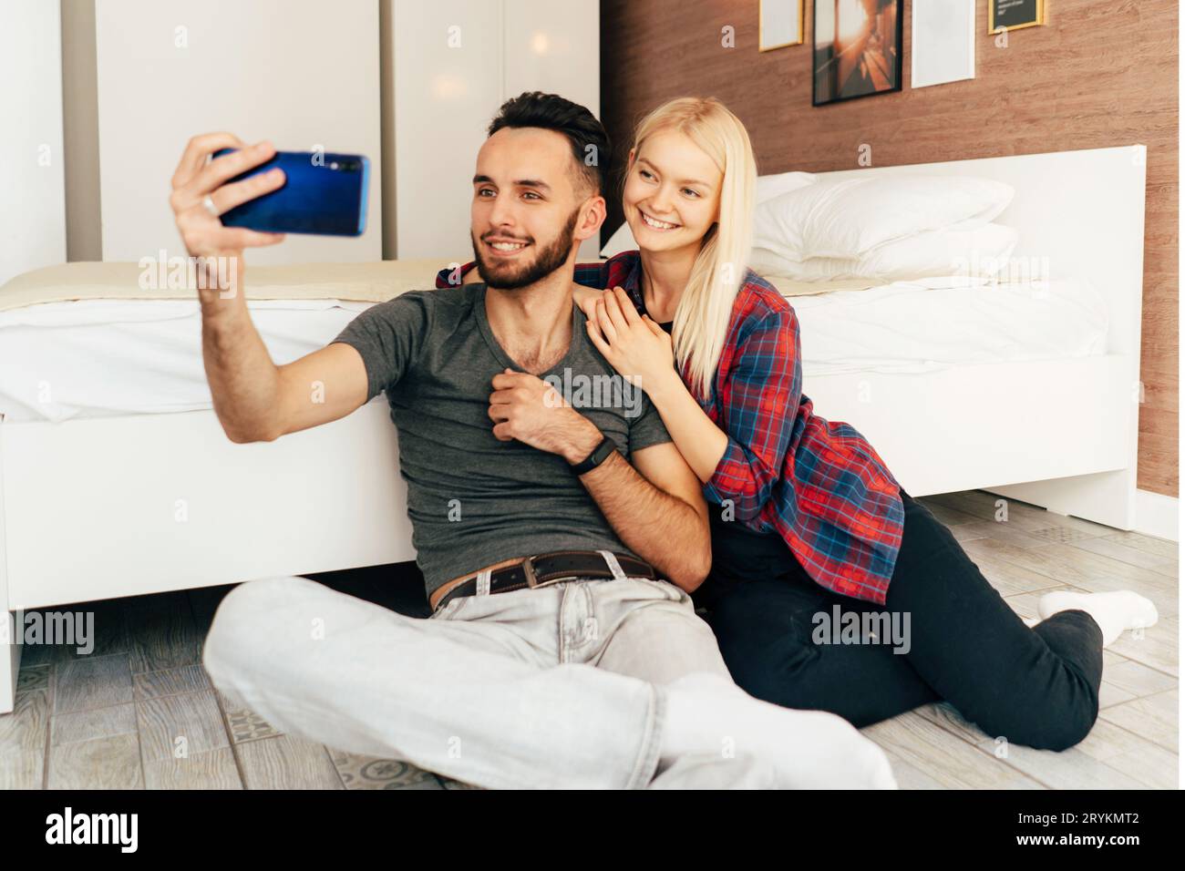 Jeune couple aimant de petit ami et de petite amie sont souriants et prendre un selfie au téléphone à la maison Banque D'Images