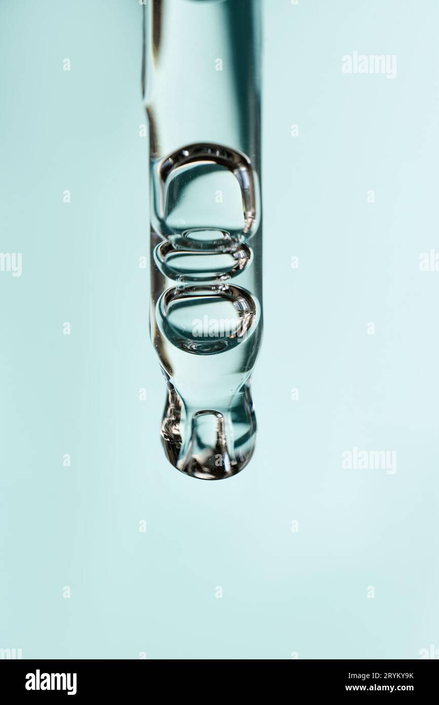 Une goutte d'huile cosmétique tombe de la pipette Banque D'Images