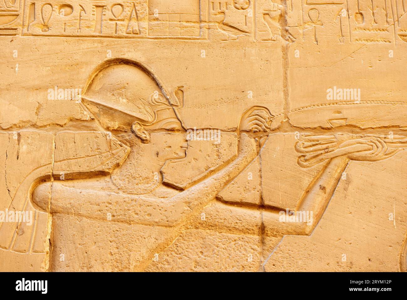 Anciens symboles égyptiens sculptés et hiéroglyphes sur les murs du temple de Karnak, en Égypte Banque D'Images
