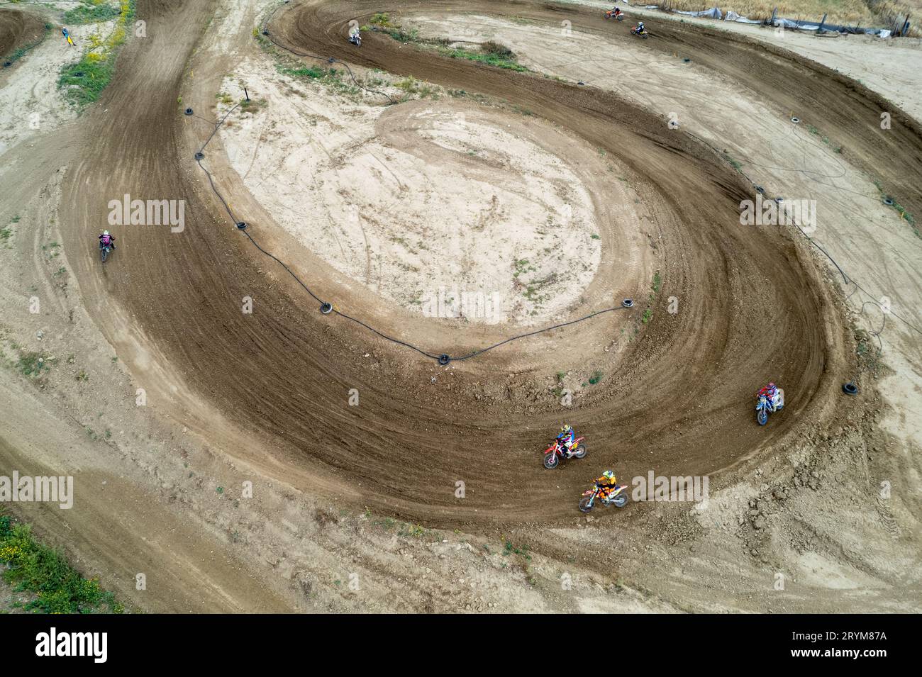 Drone AERIEN d'une course de motocross sur une piste de sport sinueuse en terre. Vue aérienne des courses à grande vitesse. Athlètes en action Banque D'Images