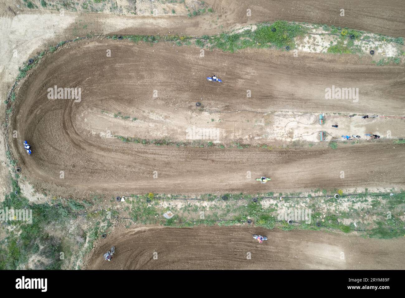 Drone AERIEN d'une course de motocross sur une piste de sport sinueuse en terre. Vue aérienne des courses à grande vitesse. Athlètes en action Banque D'Images