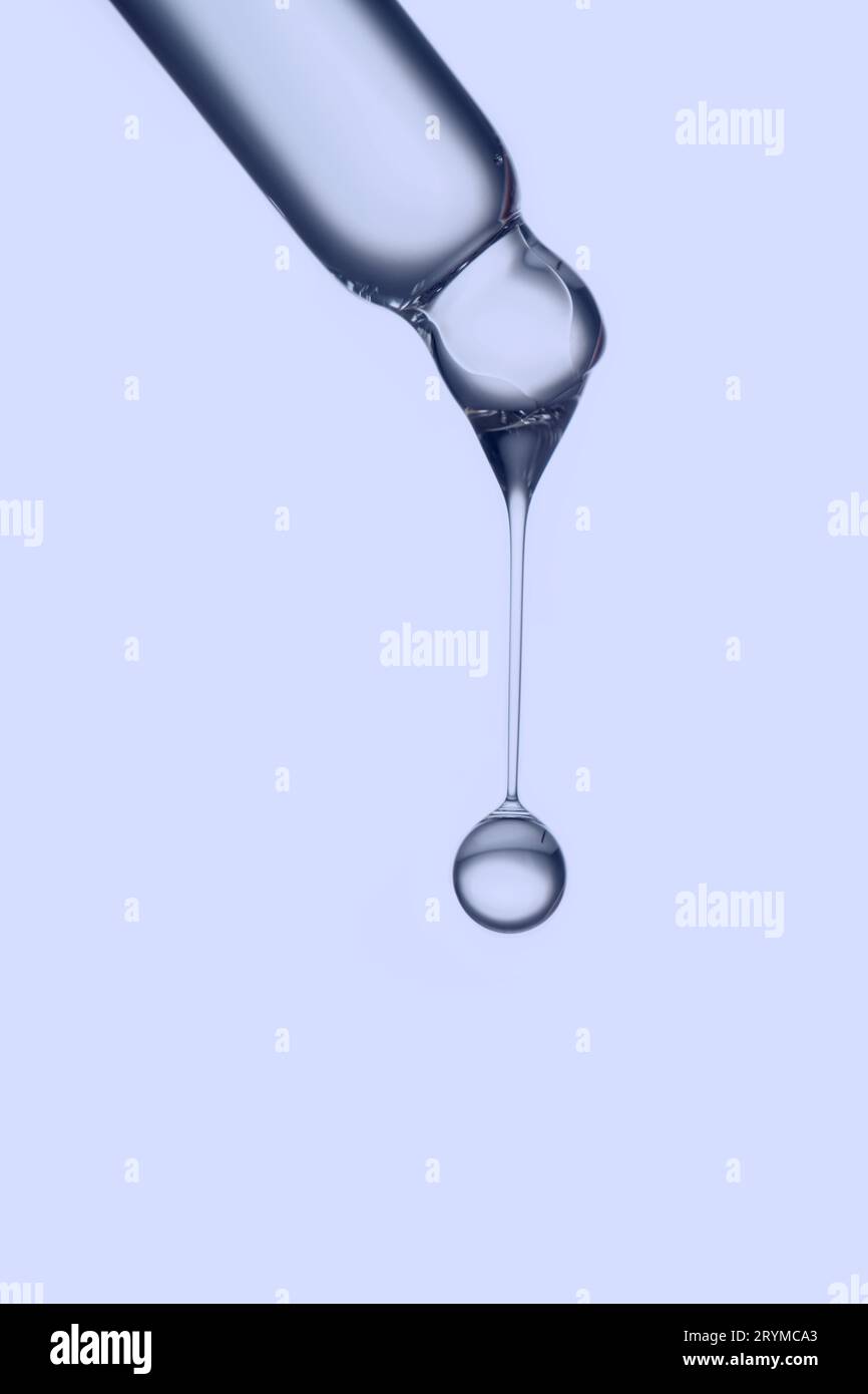 Pipeter avec une goutte de produit cosmétique sur fond violet. Banque D'Images