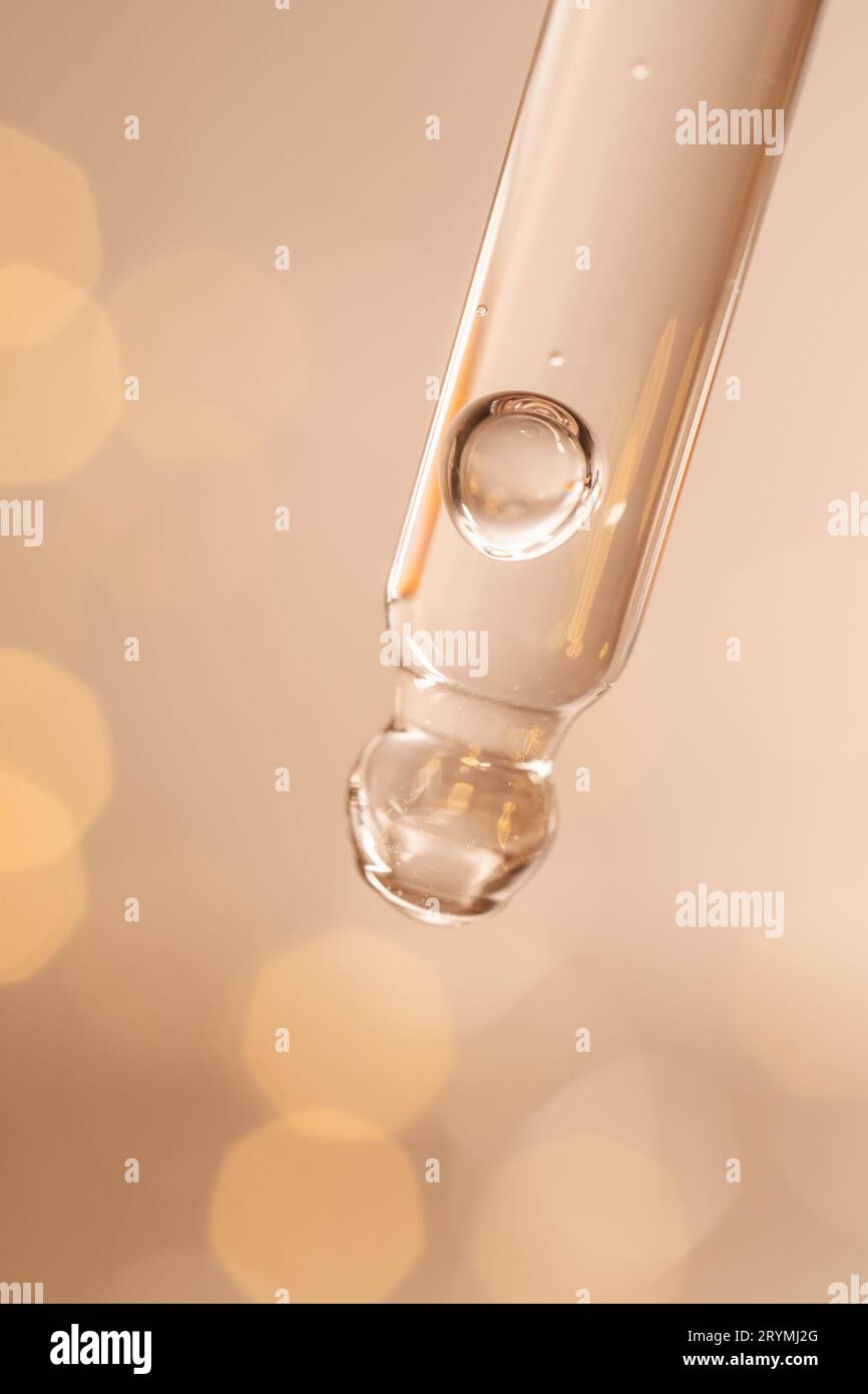 Pipeter avec du sérum sur fond beige. Banque D'Images