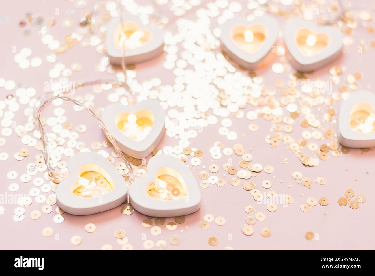 Fond monochrome festif avec guirlande de coeur et étincelles dorées. Décor de fête de Saint-Valentin ou de mariage Banque D'Images