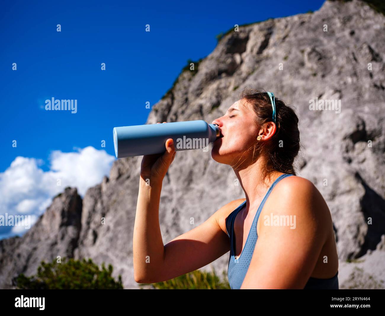 Jeune femme buvant dans une bouteille en plein air, Parc National de la Gesaeuse, Admont, Styrie, Autriche Banque D'Images