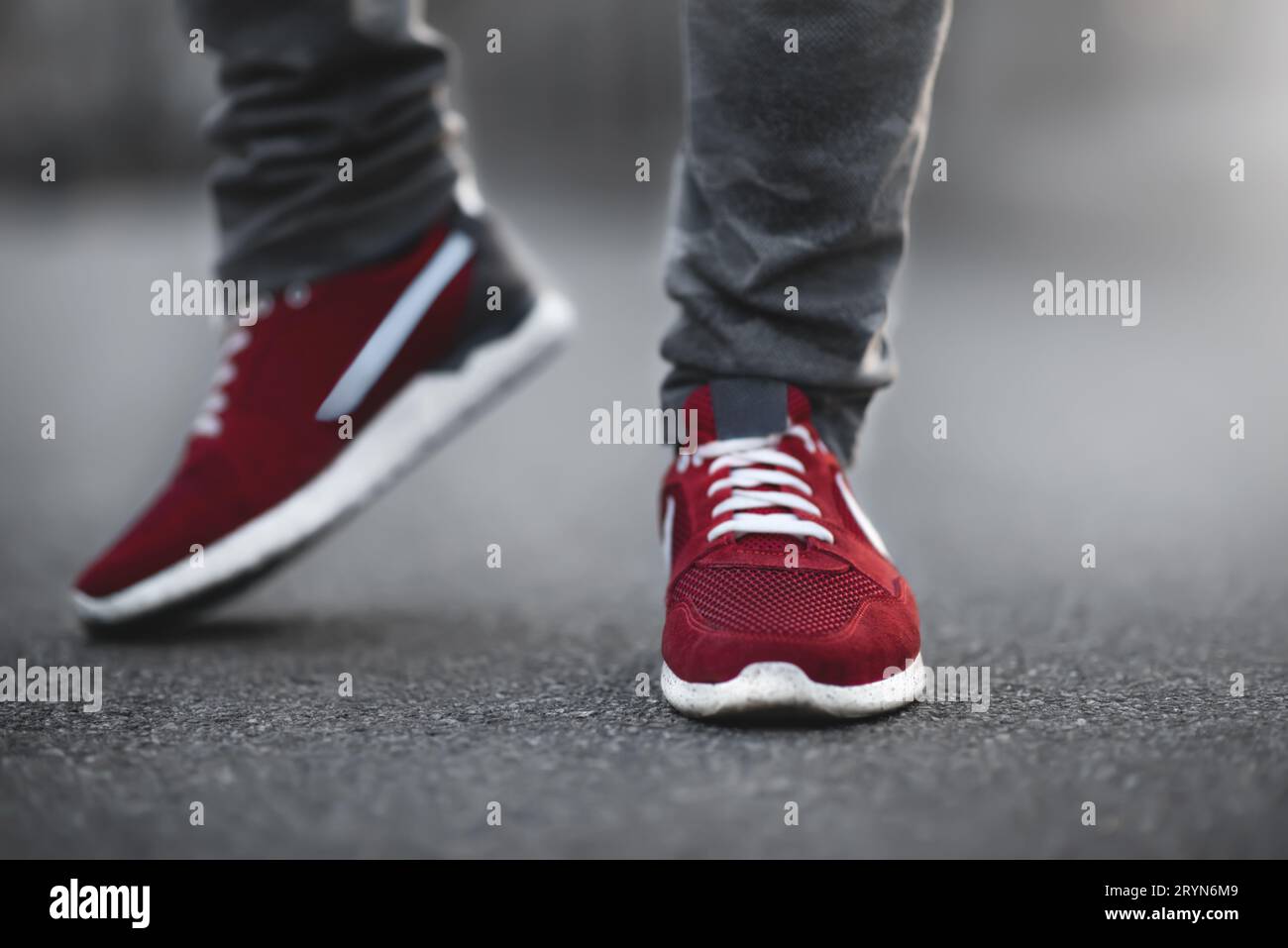 Sport baskets rouges gros plan sur asphalte. Jambes et chaussures de l'angle inférieur. Banque D'Images