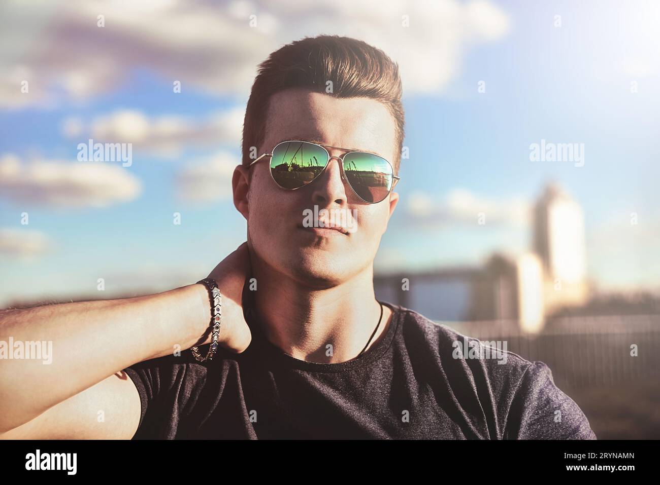 Portrait d'un beau gars élégant dans des lunettes de soleil qui pose à l'extérieur. concept de style de vie Banque D'Images