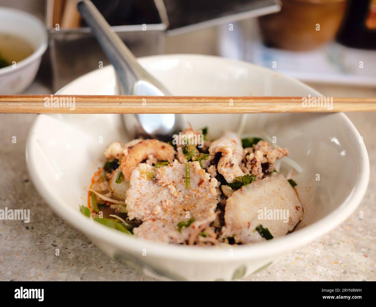 Cuisine de rue thaïlandaise. Nouilles Tom Yum, nouilles au porc et épicé chaud, gros plan Spicy TOM YAM, nouilles plates aromatisées à la citronnelle épicée avec du porc. Banque D'Images