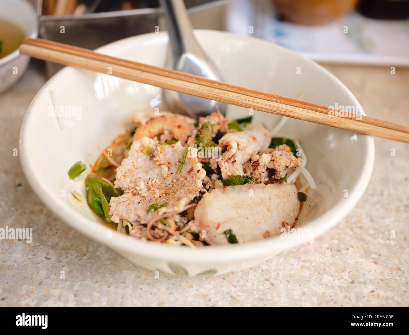 Cuisine de rue thaïlandaise. Nouilles Tom Yum, nouilles au porc et épicé chaud, gros plan Spicy TOM YAM, nouilles plates aromatisées à la citronnelle épicée avec du porc. Banque D'Images