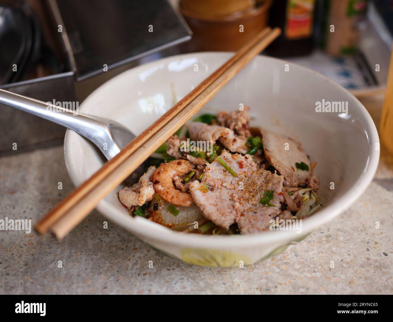 Cuisine de rue thaïlandaise. Nouilles Tom Yum, nouilles au porc et épicé chaud, gros plan Spicy TOM YAM, nouilles plates aromatisées à la citronnelle épicée avec du porc. Banque D'Images