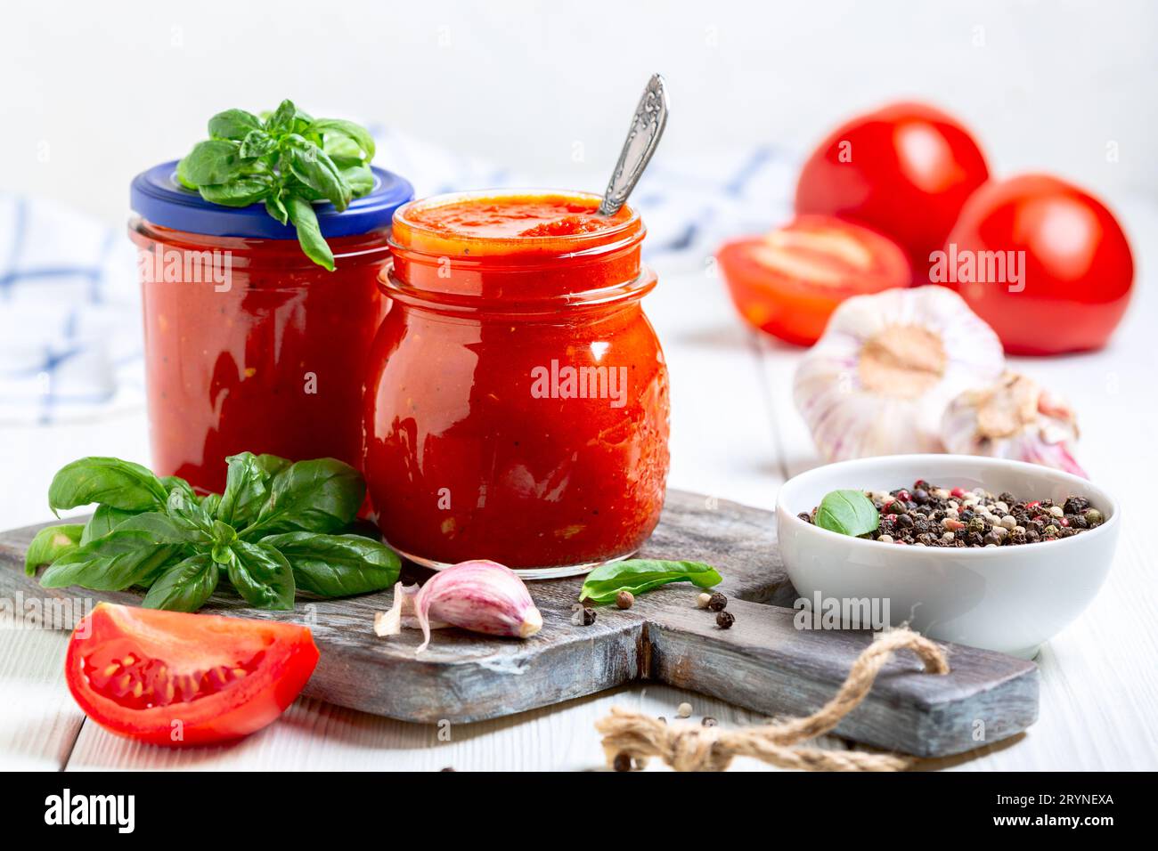 Sauce tomate napolitaine maison avec ail, poivre et basilic frais dans des bocaux en verre, mise au point sélective. Concept de cuisine maison italienne. Banque D'Images
