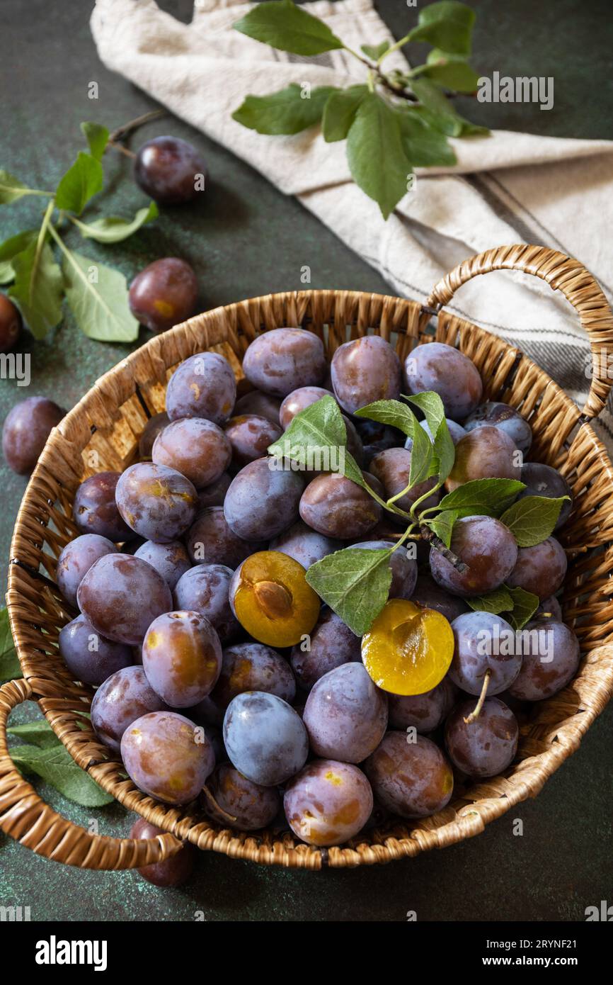 Fond de fruits, fruits biologiques. Nourriture pour encore la vie. Panier de prunes bleu frais sur une table en pierre. Banque D'Images