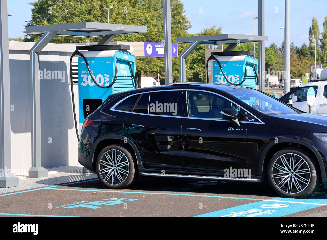Station de recharge pour véhicules électriques dans le parking d'un hypermarché Carrefour. Voyages, véhicules, pollution et transition énergétique. Brive, Corrèz Banque D'Images