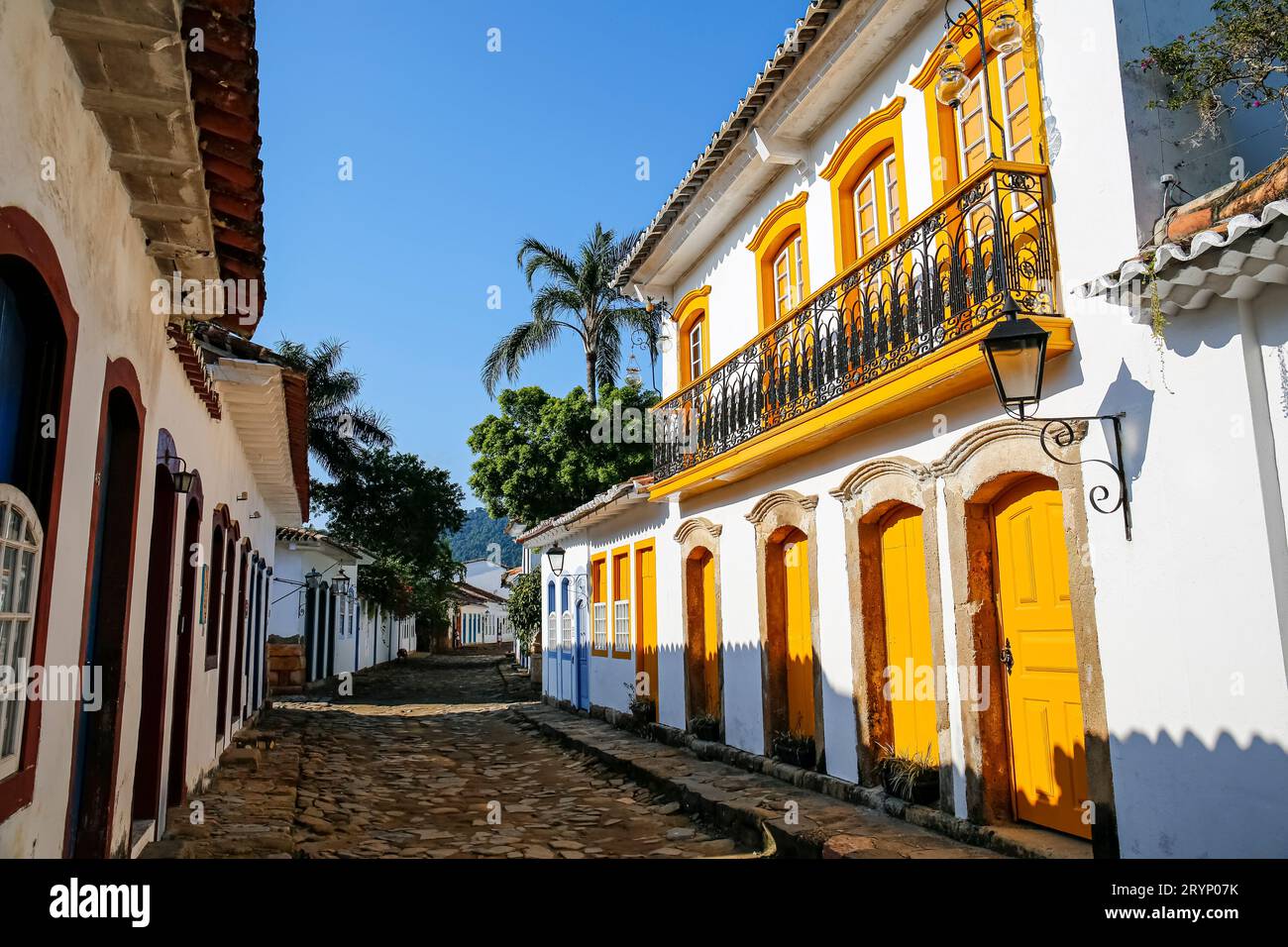 Rue étroite avec un magnifique bâtiment colonial avec portes en bois jaune, fenêtres et balustrade en fin d'après-midi soleil, histori Banque D'Images
