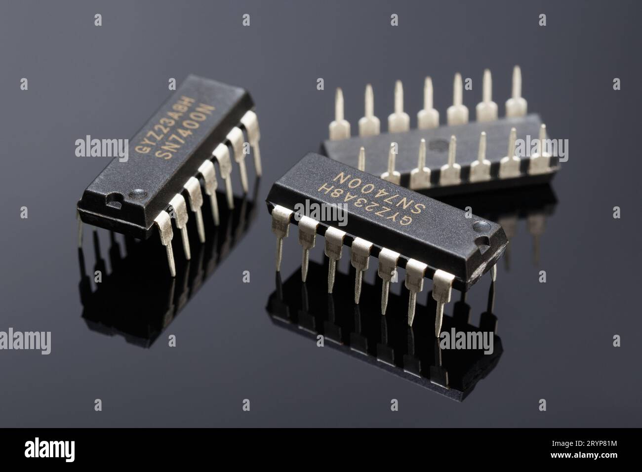 Trois puces logiques 7400 sur un fond sombre avec réflexion. Photographie macro Banque D'Images