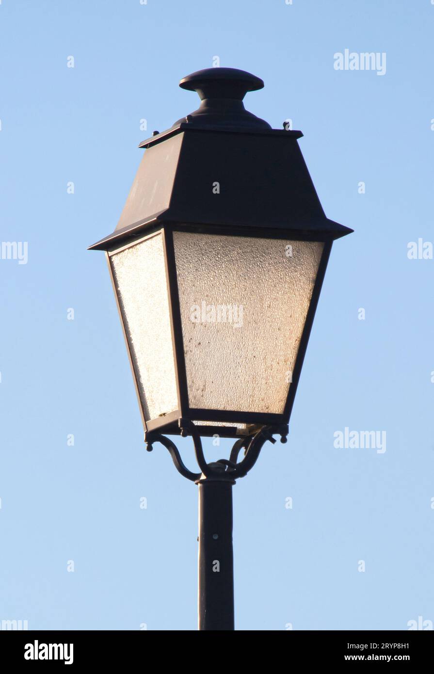 Gros plan de vieux lampadaire noir isolé sur ciel bleu Banque D'Images
