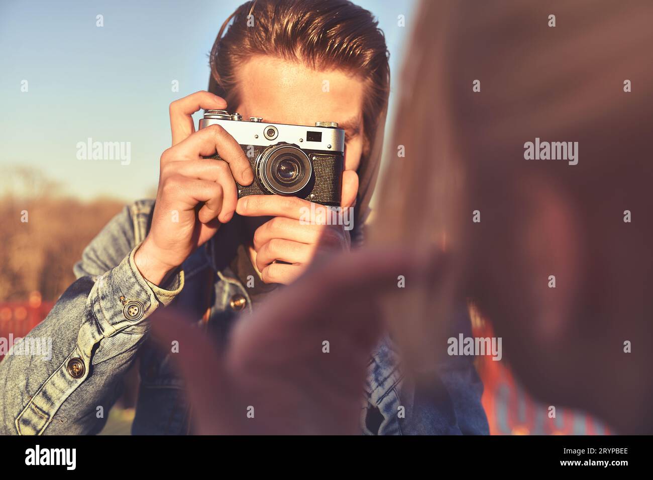 Jeune homme joyeux photographe prenant des photos avec l'appareil photo Banque D'Images