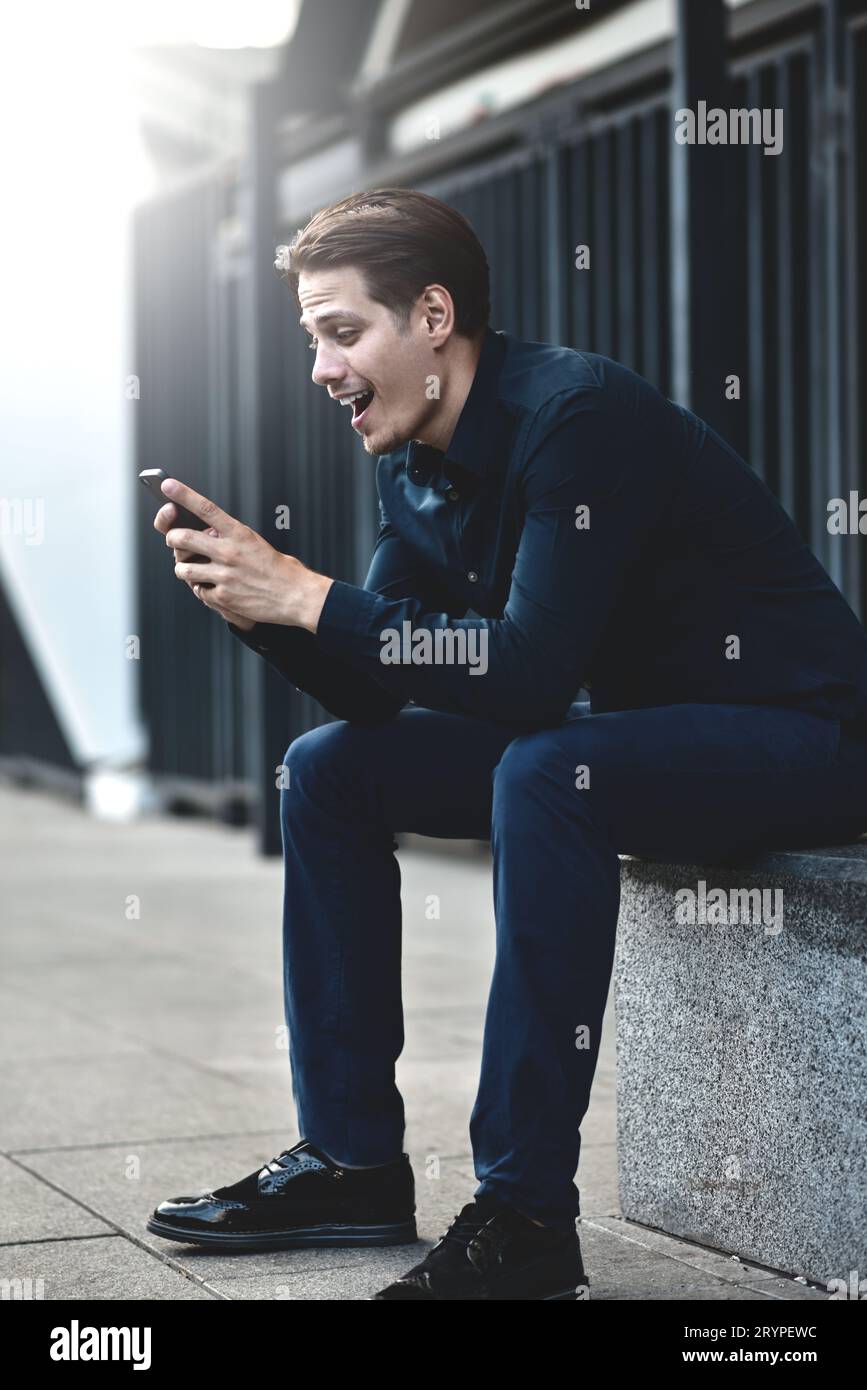 Un homme souriant parle au téléphone dans la rue ville Banque D'Images