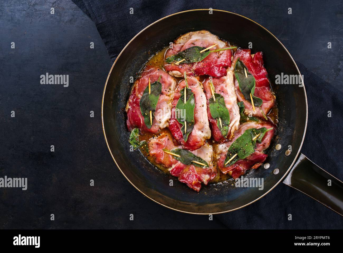 Saltimbocca alla Romana de porc frit italien traditionnel avec jambon de Parme et feuilles de sauge servi comme vue de dessus dans une poêle classique Banque D'Images