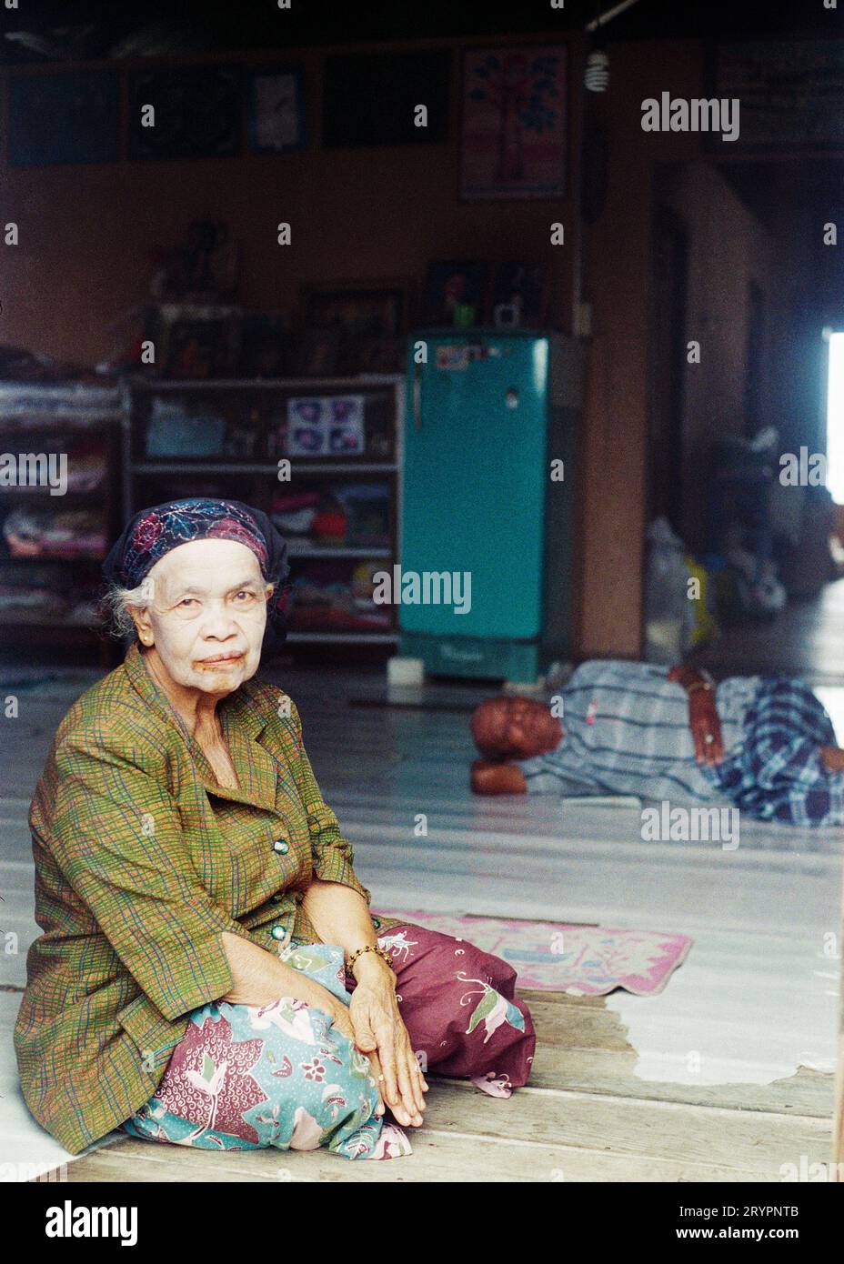 Négatif scanné de 35 mm d'une femme assise dans un abri avec un agent blanchissant sur son visage pendant une inondation sur le village flottant de Panyee, Thaïlande, mars 2011 Banque D'Images