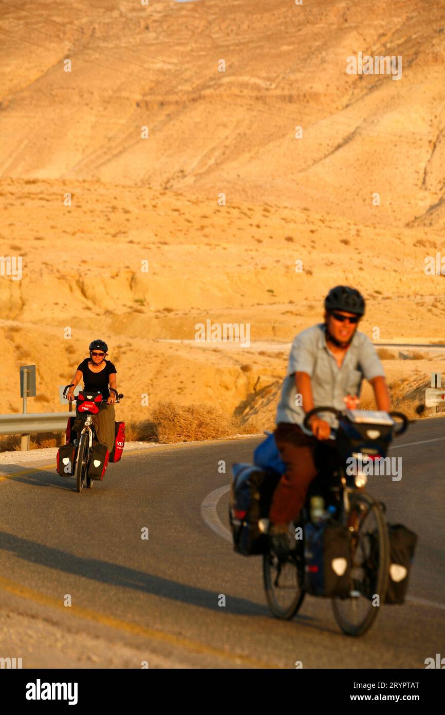Couple riding bicycles sur la route entre Dublin et la mer morte, en Jordanie. Banque D'Images