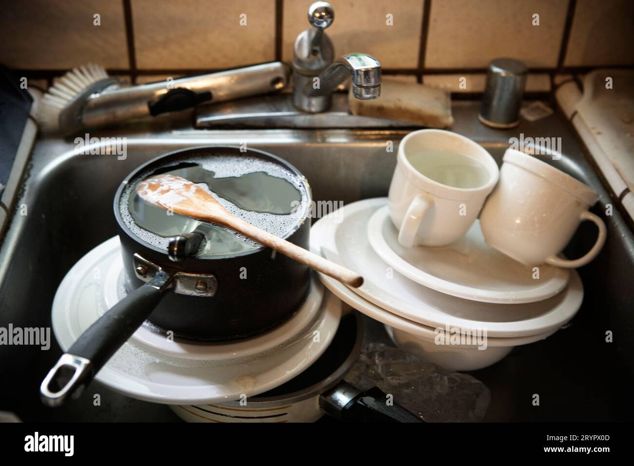 Un évier rempli de vaisselle sale. Banque D'Images