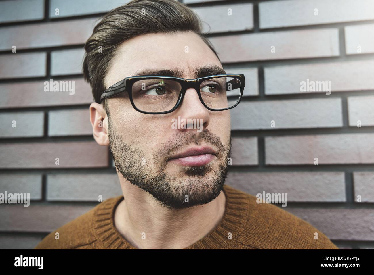 Portrait d'un bel homme caucasien dans des lunettes qui fronce sérieusement les sourcils. Concept de visage émotionnel. Banque D'Images