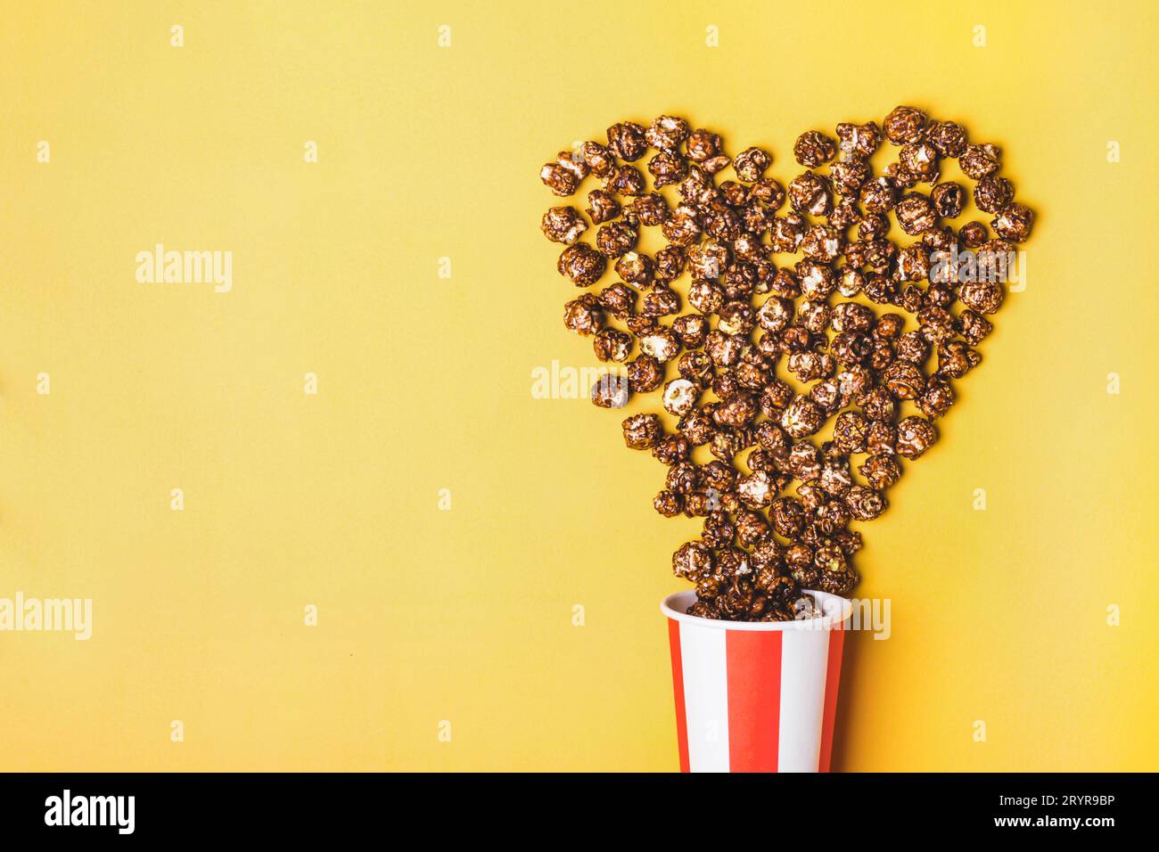 Pop-corn au chocolat doux dans une tasse rouge blanche rayée de papier Banque D'Images