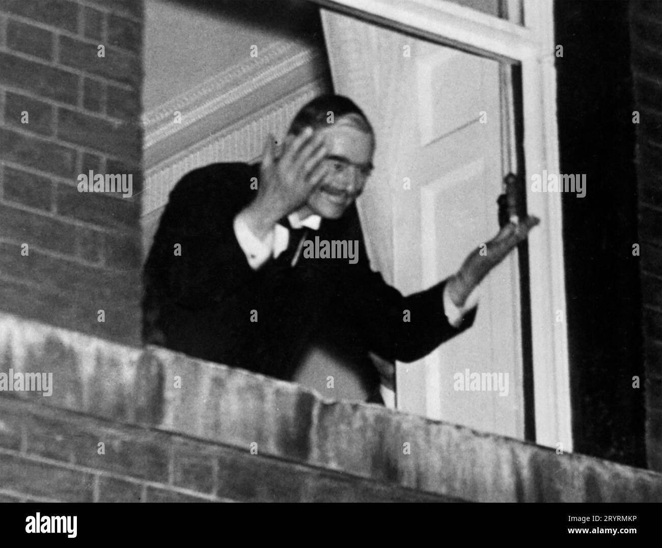 NEVILLE CHAMBERLAIN (1869-1940) Premier ministre britannique, fait signe à la foule depuis le 10 Downing Street dans la soirée du 30 septembre 1938 après son retour de Munich. Banque D'Images