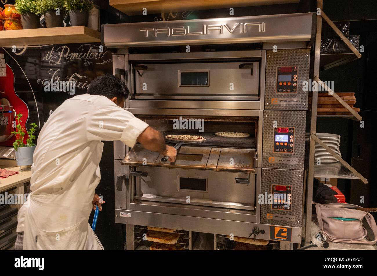 De nombreux pizzerias et restaurants sont des entreprises asiatiques à Venise, dans la région de la Vénétie, au nord de l'Italie. Un cuisinier de pizza asiatique est occupé à préparer Banque D'Images