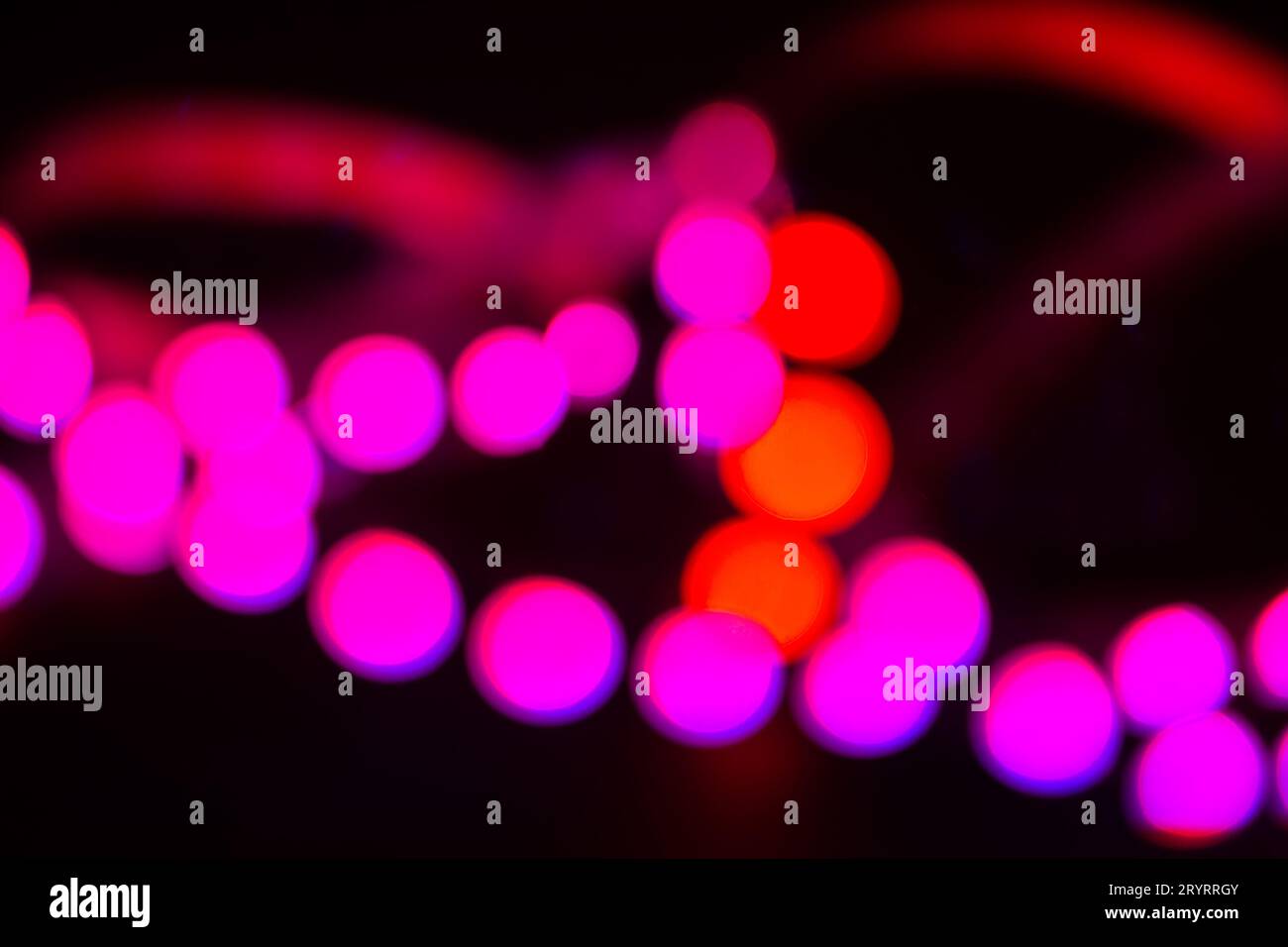 Lumières néons rouges et violettes duotones sur noir. Arrière-plan flou abstrait Banque D'Images