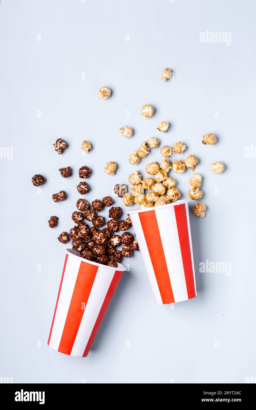 Pop-corn au chocolat caramel doux dans une tasse rouge blanche rayée de papier Banque D'Images