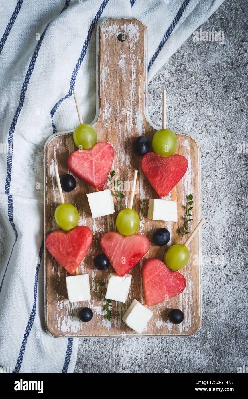 Snack pour la Saint-Valentin. Pastèque, feta et raisins sur brochettes Banque D'Images