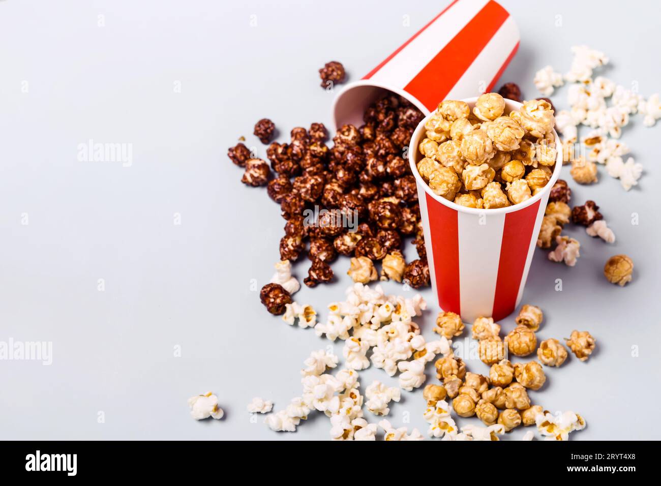Assortiment de pop-corn dans une tasse rouge blanche rayée en papier. Pop-corn sucré et salé Banque D'Images