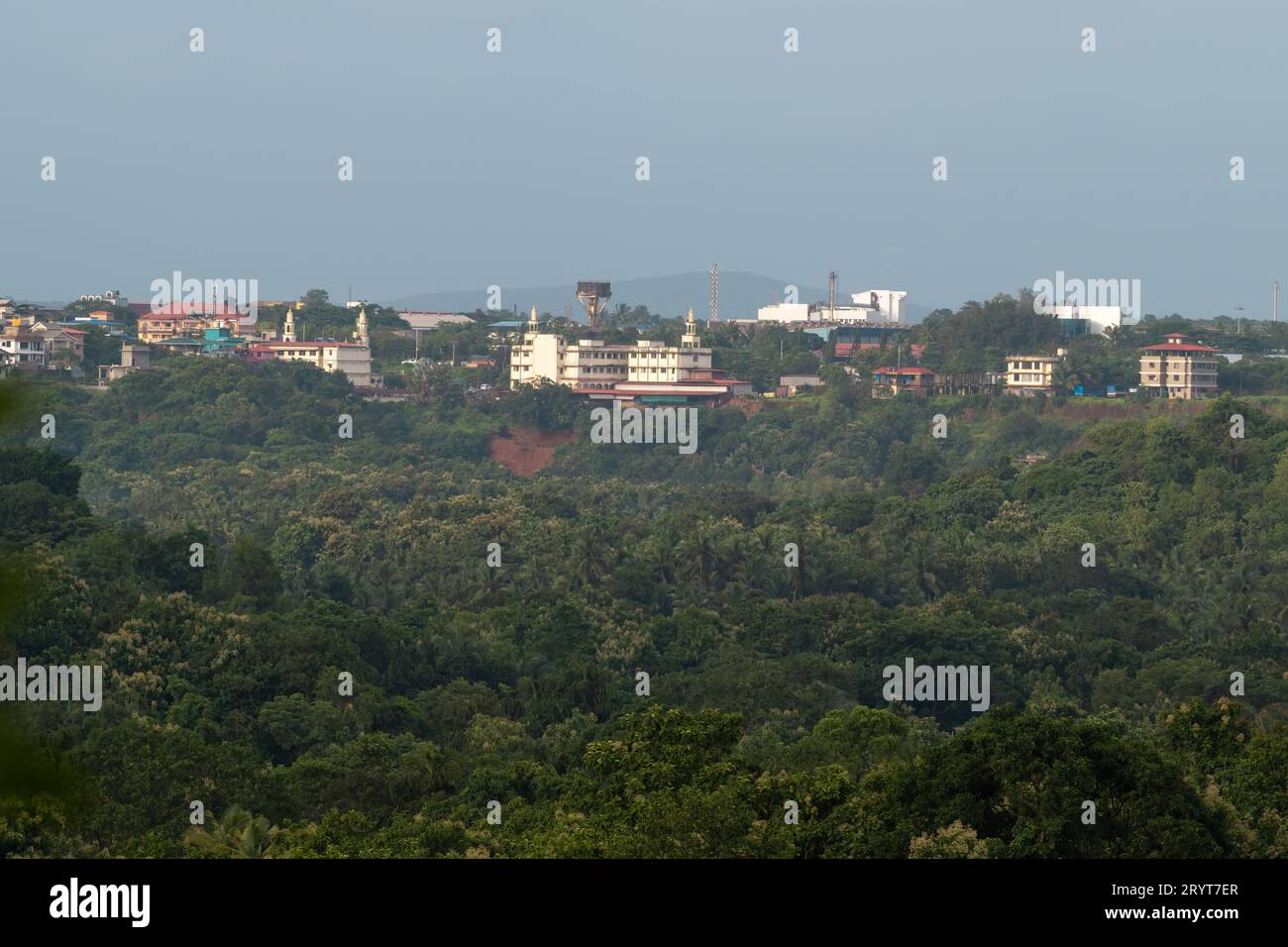 Vue sur la ville industrielle de Verna à distance et entourée par une forêt tropicale luxuriante dans l'état de Goa, en Inde. Banque D'Images