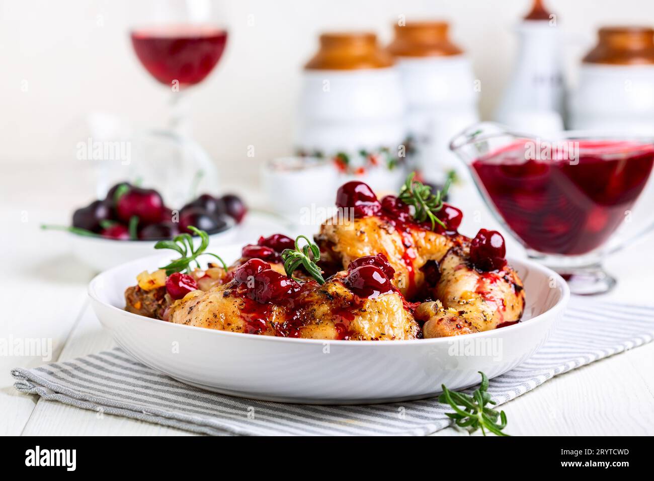 Cuisses de poulet avec sauce cerise et romarin. Banque D'Images