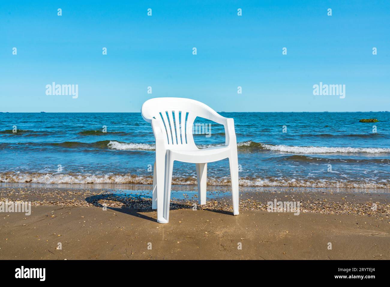 Chaise solitaire sur une plage de sable. Vacances d'été Banque D'Images