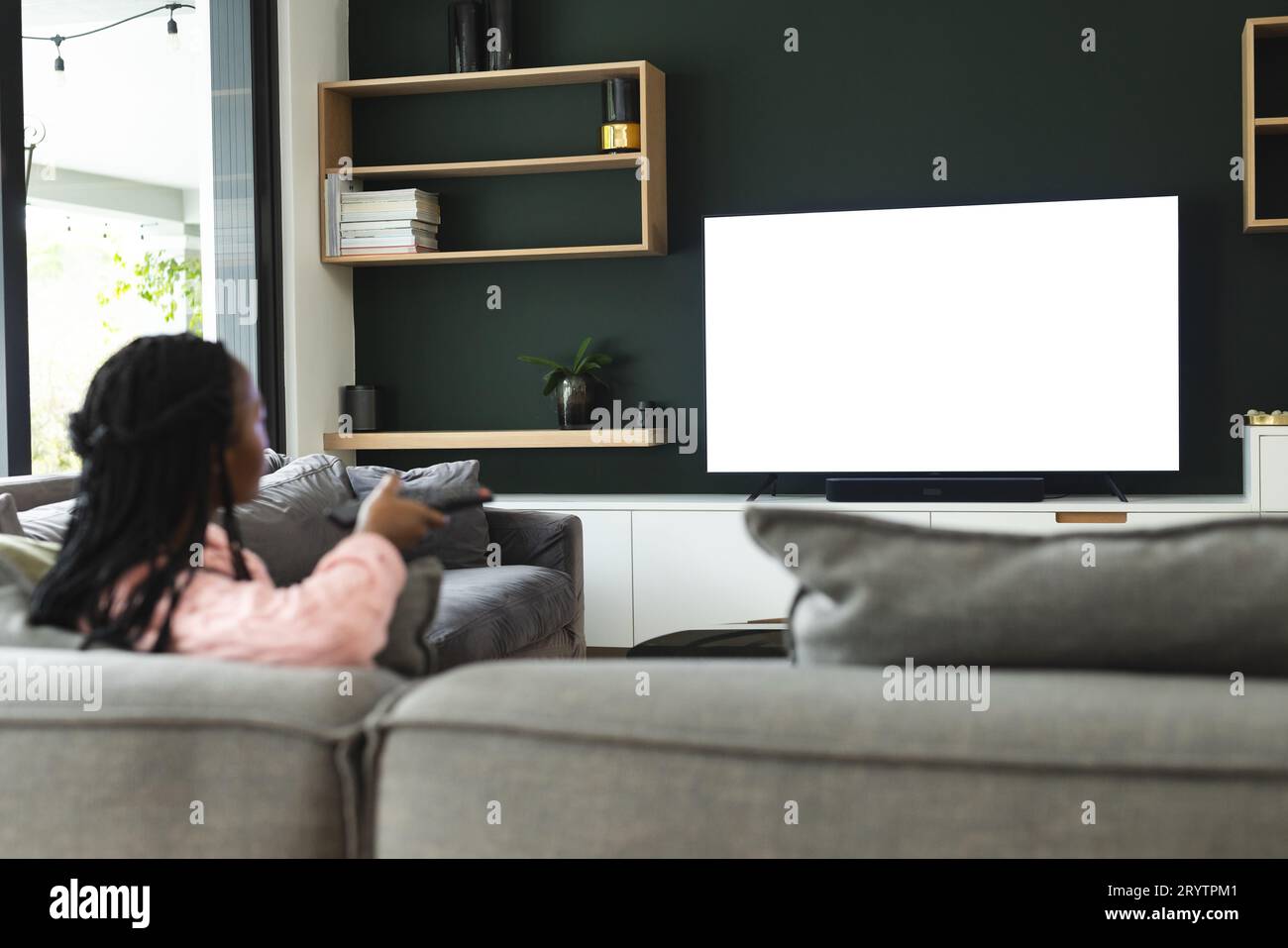 Femme afro-américaine regardant la télévision avec espace de copie, ralenti Banque D'Images