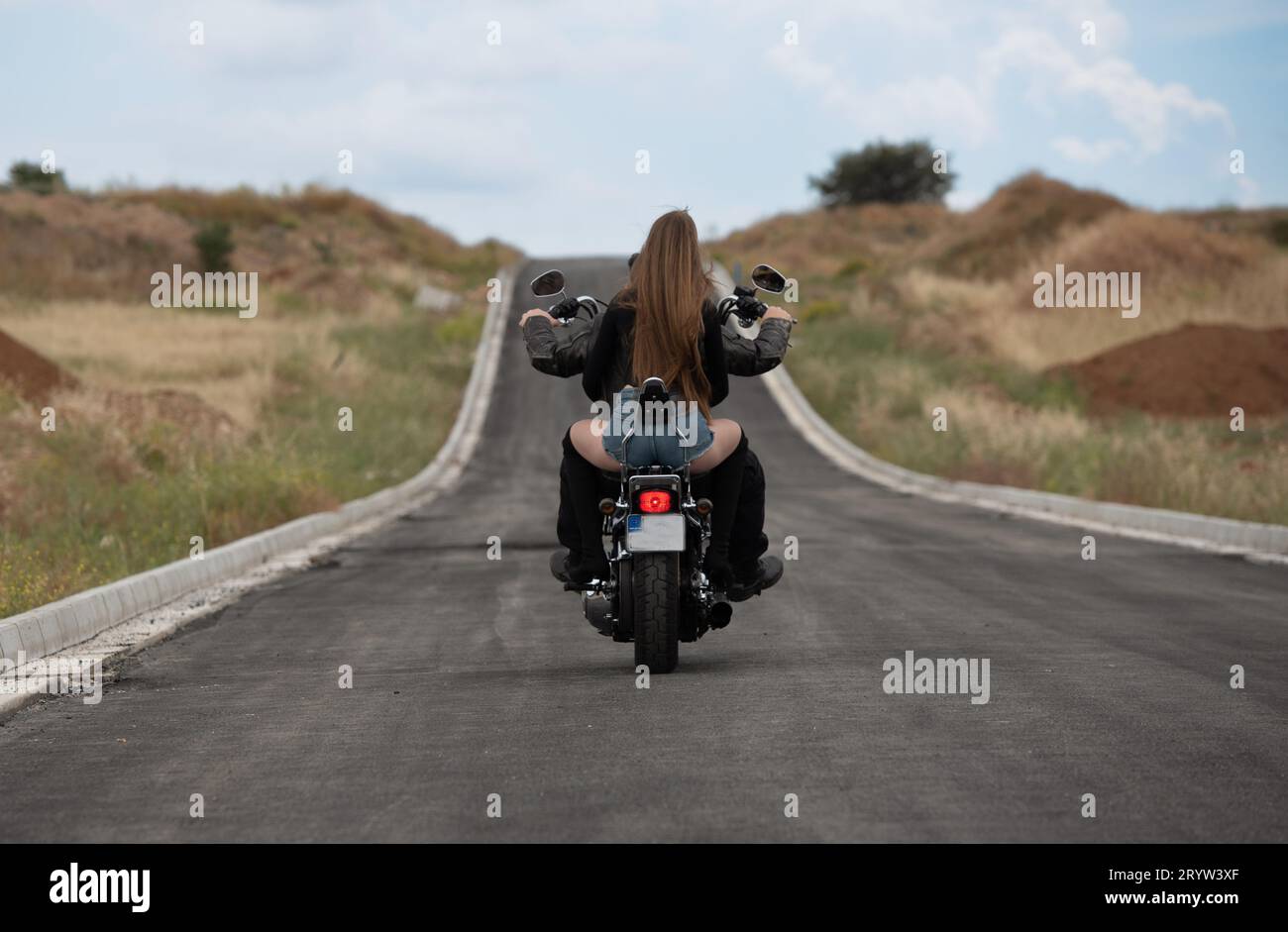 Sexy femme portant avec blonde cheveux longs équitation d'une moto de rue à l'extérieur. Exploration aventure voyage, vélo de rue Banque D'Images