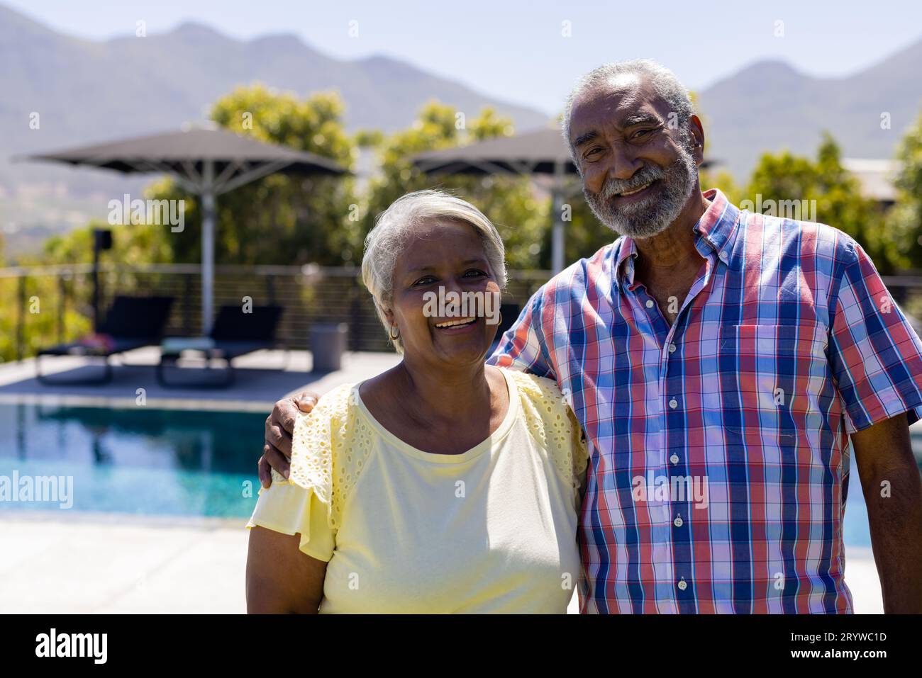Portrait d'heureux couple biracial senior embrassant et souriant dans le jardin Banque D'Images